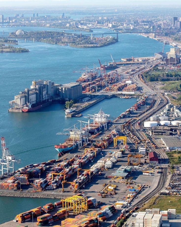 Top-down aerial of a port channel with vessels under way beside container terminals